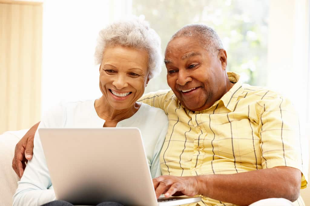 Happy couple looking at a laptop computer