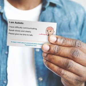 Man holding communication ID card that says, "I am autistic. I have difficulty communicating. Speak slowly and clearly. Please give me time to talk."