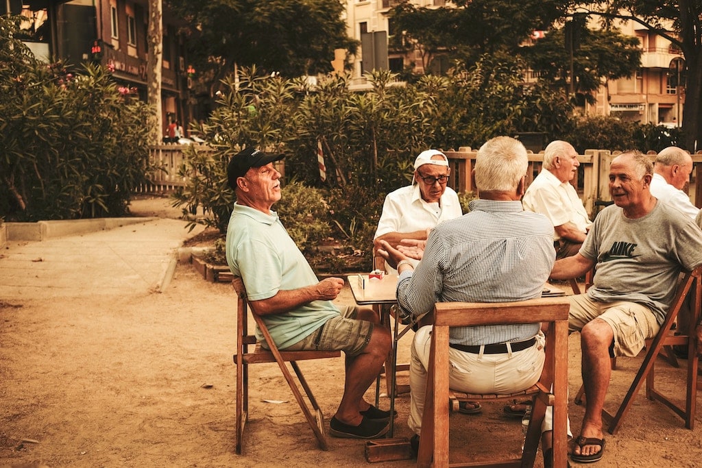 senior men sitting outdoors at a table