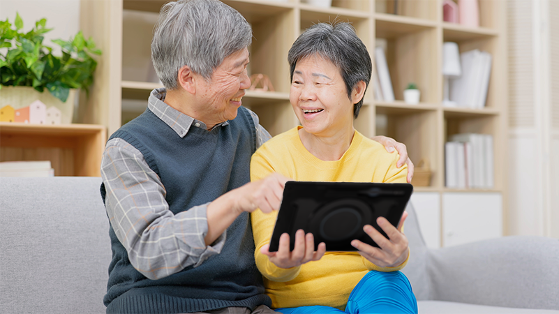 Happy couple using Lingraphica AAC device to help communication