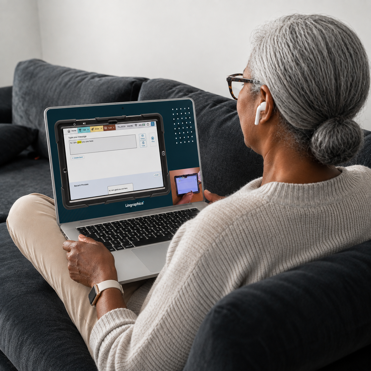 AAC device demo displayed on a laptop as an older woman watches a virtual demonstration from her couch.